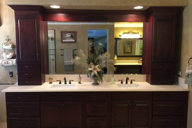 Bathroom - large traditional master bathroom idea in Los Angeles with raised-panel cabinets, dark wood cabinets, brown walls and solid surface countertops