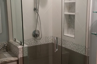 サンフランシスコにある中くらいなトランジショナルスタイルのおしゃれなバスルーム (浴槽なし) (シェーカースタイル扉のキャビネット、グレーのキャビネット、コーナー設置型シャワー、白い壁、アンダーカウンター洗面器、大理石の洗面台、開き戸のシャワー) の写真