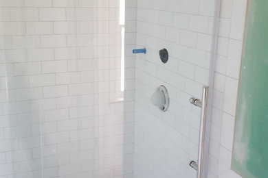 Diseño de cuarto de baño clásico renovado de tamaño medio con ducha empotrada, sanitario de dos piezas, baldosas y/o azulejos blancos, baldosas y/o azulejos de cemento, paredes blancas, suelo de mármol y aseo y ducha