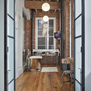 Immagine di una grande stanza da bagno padronale industriale con vasca freestanding, top in marmo, doccia alcova, lavabo a consolle, pareti rosse, pavimento in legno massello medio, pavimento marrone, nessun'anta, ante in legno scuro, piastrelle rosse e doccia aperta