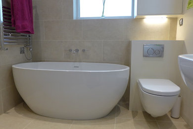 Modern inredning av ett litet badrum med dusch, med ett väggmonterat handfat, ett fristående badkar, en öppen dusch, beige kakel, porslinskakel och klinkergolv i porslin