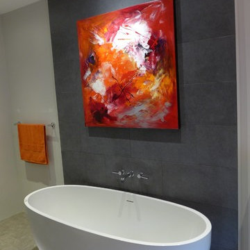 freestanding bath with grey tiled feature wall