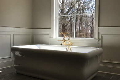 ローリーにある高級な広いコンテンポラリースタイルのおしゃれなマスターバスルーム (置き型浴槽、グレーの壁、磁器タイルの床、グレーの床) の写真