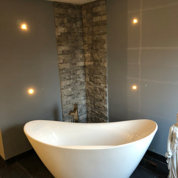 freestanding tub with limestone feature wall