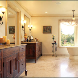 Large elegant master brown tile and porcelain tile yellow floor bathroom photo in Portland with an undermount sink, furniture-like cabinets, dark wood cabinets, granite countertops, a two-piece toilet, yellow walls and a hinged shower door