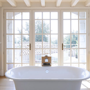 Réalisation d'une grand salle de bain principale champêtre avec une vasque, un placard sans porte, des portes de placard en bois clair, un plan de toilette en bois, une baignoire indépendante, un carrelage bleu, carrelage en mosaïque et un sol en bois clair.