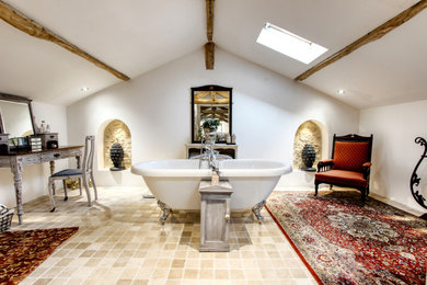 Photo of a farmhouse bathroom in Edinburgh with a freestanding bath, white walls, travertine flooring and beige floors.