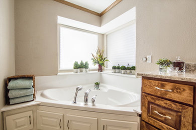 Example of a large transitional master porcelain tile and beige floor corner bathtub design in Dallas with raised-panel cabinets, dark wood cabinets, beige walls, an undermount sink and granite countertops