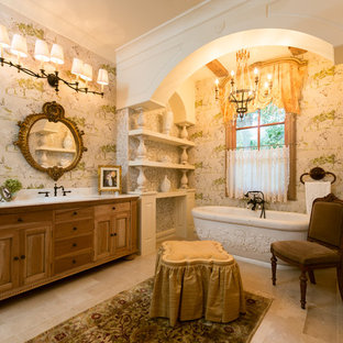 Inspiration for a french country freestanding bathtub remodel in Houston with medium tone wood cabinets, a drop-in sink and raised-panel cabinets