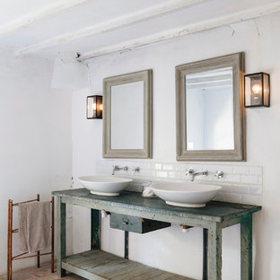 This is an example of a large mediterranean master bathroom in Toulouse with distressed cabinets, subway tile, white walls, terra-cotta floors, a vessel sink, wood benchtops and blue benchtops.