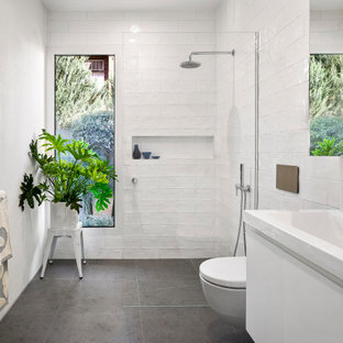 Large contemporary 3/4 bathroom in Melbourne with flat-panel cabinets, white cabinets, an open shower, a wall-mount toilet, white tile, ceramic tile, white walls, porcelain floors, an integrated sink, grey floor, an open shower, yellow benchtops, a niche and a floating vanity.