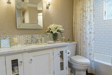 Idée de décoration pour une salle de bain tradition avec des portes de placard blanches, un mur beige, parquet foncé et un plan de toilette en marbre.