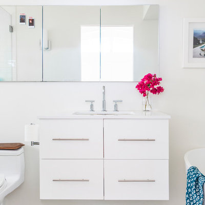 Example of a mid-sized transitional master blue tile and cement tile concrete floor bathroom design in Los Angeles with flat-panel cabinets, white cabinets, a one-piece toilet, white walls, an undermount sink and quartz countertops