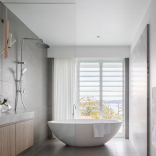 Large contemporary wet room bathroom in Sydney with a freestanding tub, granite benchtops, flat-panel cabinets, light wood cabinets, gray tile, white walls, an undermount sink, grey floor, grey benchtops and a floating vanity.