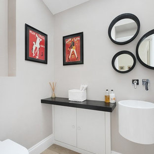 Modelo de cuarto de baño minimalista con lavabo suspendido, armarios con paneles lisos y puertas de armario blancas