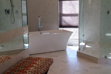 Modelo de cuarto de baño principal moderno grande con bañera exenta, ducha empotrada, sanitario de dos piezas, baldosas y/o azulejos blancos, paredes blancas y lavabo bajoencimera
