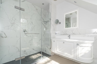 Inspiration for a medium sized classic shower room bathroom in Buckinghamshire with shaker cabinets, white cabinets, a wall mounted toilet, white tiles, porcelain tiles, white walls, porcelain flooring, an integrated sink, solid surface worktops, beige floors, a hinged door and white worktops.