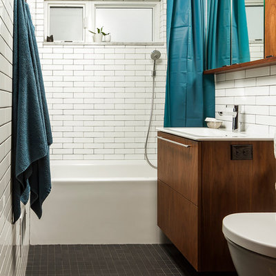 Mid-sized eclectic white tile and ceramic tile porcelain tile and black floor bathroom photo in Minneapolis with flat-panel cabinets, brown cabinets, a wall-mount toilet, white walls and an integrated sink