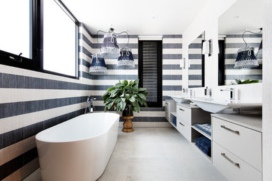 Design ideas for a large contemporary ensuite bathroom in Melbourne with flat-panel cabinets, grey cabinets, a freestanding bath, black and white tiles, ceramic tiles, ceramic flooring, a vessel sink, engineered stone worktops and beige floors.