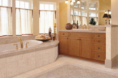 Bild på ett mellanstort en-suite badrum, med ett nedsänkt handfat, skåp i shakerstil, skåp i mellenmörkt trä, ett platsbyggt badkar, beige kakel, gula väggar och klinkergolv i keramik