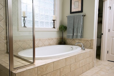 Foto de cuarto de baño principal actual grande con bañera esquinera, baldosas y/o azulejos beige, baldosas y/o azulejos de cerámica, paredes beige y suelo de baldosas de cerámica