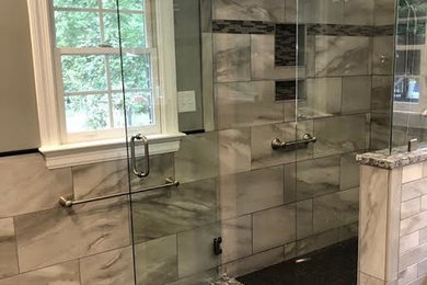 Bathroom - mid-sized transitional master beige tile and porcelain tile porcelain tile and black floor bathroom idea in Richmond with recessed-panel cabinets, white cabinets, a two-piece toilet, green walls, an undermount sink, granite countertops, a hinged shower door and black countertops
