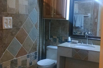 This is an example of a medium sized traditional shower room bathroom in Houston with open cabinets, white cabinets, an alcove shower, a two-piece toilet, beige tiles, porcelain tiles, beige walls, porcelain flooring, a submerged sink, granite worktops, grey floors and a shower curtain.