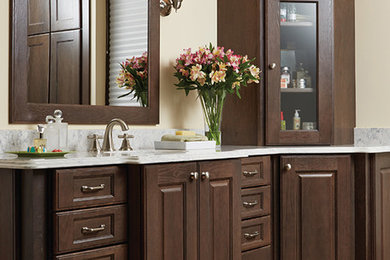 Example of a marble floor bathroom design in Other with raised-panel cabinets, dark wood cabinets, beige walls, an integrated sink and marble countertops