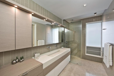 Example of a mid-sized minimalist master gray tile and glass tile marble floor doorless shower design in Miami with an integrated sink, flat-panel cabinets, medium tone wood cabinets, quartz countertops, a two-piece toilet and gray walls