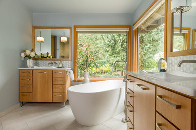 Inspiration for a transitional master blue tile and porcelain tile porcelain tile and beige floor bathroom remodel in Portland with flat-panel cabinets, light wood cabinets, a one-piece toilet, blue walls, a drop-in sink, quartz countertops, a hinged shower door and white countertops
