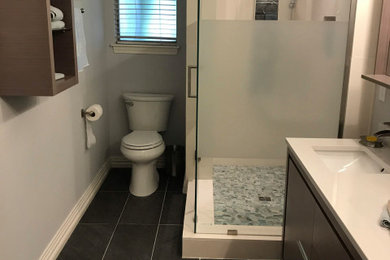 Bathroom - mid-sized contemporary master white tile and limestone tile porcelain tile and black floor bathroom idea in Houston with flat-panel cabinets, gray cabinets, gray walls, an undermount sink, quartz countertops and white countertops