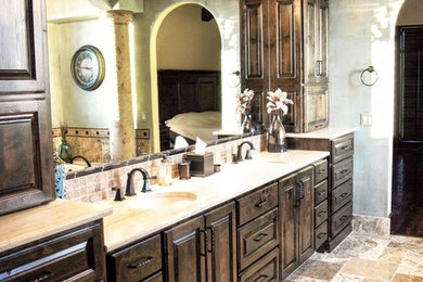 Large tuscan master beige tile, brown tile and stone tile marble floor bathroom photo in Kansas City with dark wood cabinets, recessed-panel cabinets, a two-piece toilet, blue walls, an undermount sink and solid surface countertops