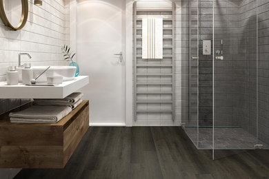 Mittelgroßes Modernes Duschbad mit Eckdusche, grauen Fliesen, weißer Wandfarbe, dunklem Holzboden, Aufsatzwaschbecken, Mineralwerkstoff-Waschtisch, schwarzem Boden, Falttür-Duschabtrennung und weißer Waschtischplatte in Orange County