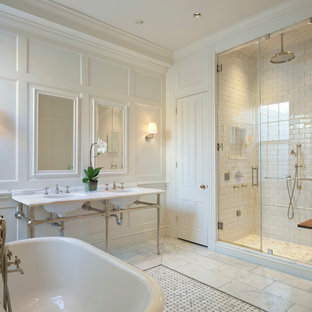 Design ideas for a traditional ensuite bathroom in DC Metro with a freestanding bath, white tiles, ceramic tiles, white walls, marble flooring, marble worktops and a console sink.