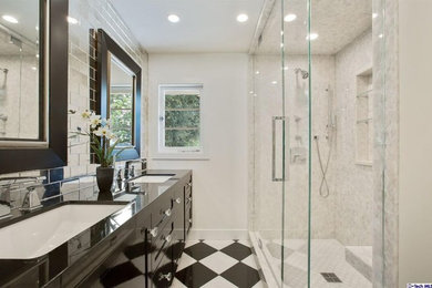 Example of a mid-sized transitional 3/4 gray tile and stone tile marble floor double shower design in Los Angeles with shaker cabinets, black cabinets, white walls, an undermount sink and granite countertops