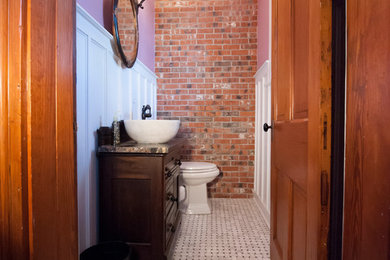 Modelo de cuarto de baño rural pequeño con armarios con paneles con relieve, puertas de armario negras, paredes púrpuras, suelo con mosaicos de baldosas, aseo y ducha, lavabo sobreencimera y encimera de granito