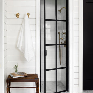 Immagine di una stanza da bagno country con doccia alcova, piastrelle bianche, piastrelle diamantate, pareti bianche, pavimento grigio e porta doccia a battente