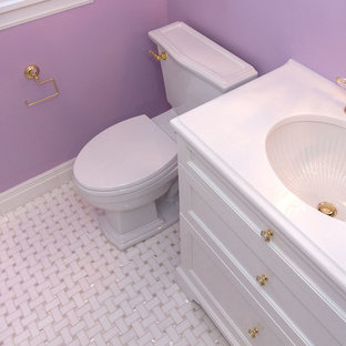 Inspiration pour une salle d'eau traditionnelle de taille moyenne avec un placard à porte affleurante, des portes de placard blanches, un WC à poser, un mur violet, un sol en marbre, un lavabo encastré et un plan de toilette en marbre.