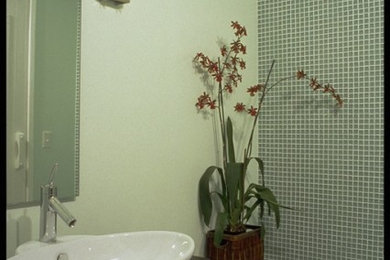 サンフランシスコにあるお手頃価格の中くらいなコンテンポラリースタイルのおしゃれな浴室 (ベッセル式洗面器、家具調キャビネット、濃色木目調キャビネット、コーナー型浴槽、シャワー付き浴槽	、一体型トイレ	、緑のタイル、ガラスタイル、緑の壁、磁器タイルの床) の写真