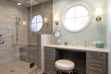 Alcove shower - large transitional master gray tile and porcelain tile medium tone wood floor and brown floor alcove shower idea in New York with recessed-panel cabinets, gray cabinets, a one-piece toilet, blue walls, an undermount sink, quartz countertops and a hinged shower door