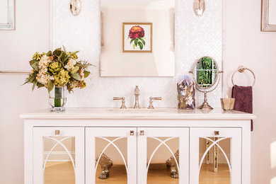 Foto di una stanza da bagno moderna con consolle stile comò, ante bianche, vasca con piedi a zampa di leone, piastrelle bianche, parquet chiaro e top in marmo