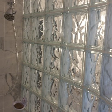 Glass block walk in shower with ceramic marble looking tiles