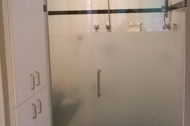 Ejemplo de cuarto de baño clásico renovado con armarios con paneles lisos, puertas de armario blancas, combinación de ducha y bañera, baldosas y/o azulejos negros, baldosas y/o azulejos blancos y baldosas y/o azulejos de cemento
