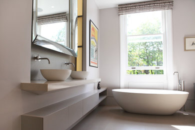 На фото: большая главная ванная комната в современном стиле с плоскими фасадами, серыми фасадами, отдельно стоящей ванной, двойным душем, инсталляцией, серой плиткой, керамогранитной плиткой, серыми стенами, полом из керамогранита и столешницей из кварцита с
