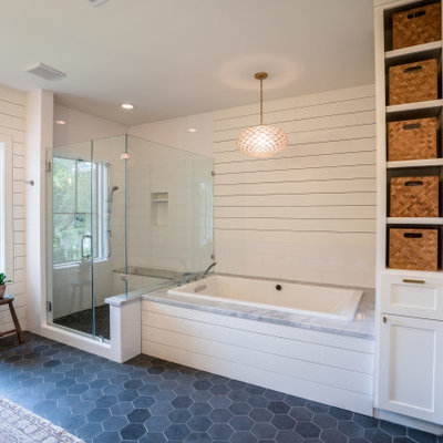 Example of a large transitional master white tile and subway tile porcelain tile, gray floor, double-sink and shiplap wall bathroom design in Houston with furniture-like cabinets, medium tone wood cabinets, an undermount tub, a one-piece toilet, white walls, an undermount sink, marble countertops, a hinged shower door, gray countertops and a freestanding vanity