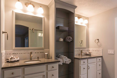 Ejemplo de cuarto de baño principal tradicional grande con armarios con paneles con relieve, puertas de armario blancas y paredes grises