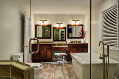 Example of a mid-sized transitional master laminate floor and gray floor bathroom design in New York with shaker cabinets, dark wood cabinets, a one-piece toilet, gray walls, an undermount sink, granite countertops and a hinged shower door