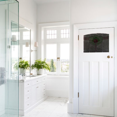 Inspiration for a timeless white tile marble floor corner shower remodel in Melbourne with an undermount sink, shaker cabinets, white cabinets, marble countertops and white walls