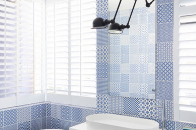 ブリスベンにあるコンテンポラリースタイルのおしゃれな浴室 (フラットパネル扉のキャビネット、白いキャビネット、置き型浴槽、青いタイル、ベッセル式洗面器、白い洗面カウンター、洗面台1つ、フローティング洗面台) の写真