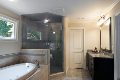 Cette image montre une salle de bain traditionnelle en bois foncé avec un lavabo encastré, un placard avec porte à panneau surélevé, un plan de toilette en granite, une baignoire posée, une douche d'angle et un carrelage beige.